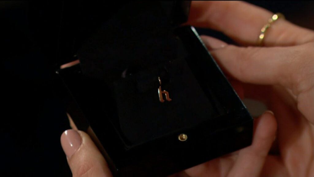 Kyle gives Summer a small gold pendant in the shape of an H