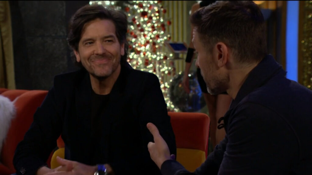 Danny jokes with Daniel. A Christmas tree is in the background.