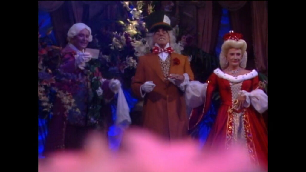 Rex Sterling, as the Mad Hatter, and Katherine Chancellor, dressed as The Queen of Hearts, are introduced by the majordomo