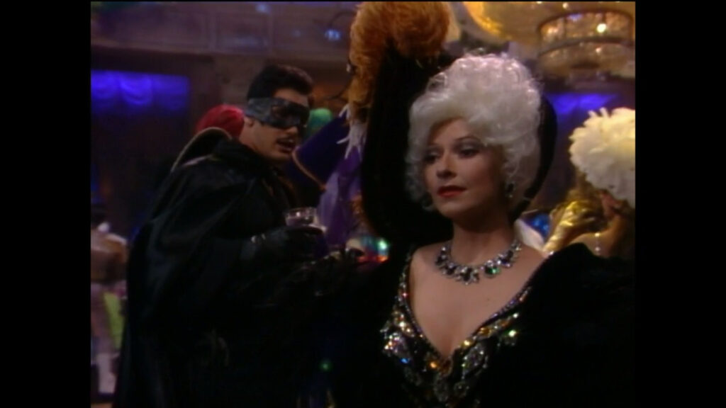 Brad Carlton, dressed as Zorro, brings Traci Abbott (dressed as Mae West) a drink