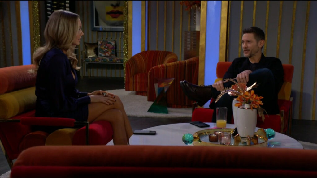 Abby and Daniel talk while sitting on comfy-looking chairs in the Glam Club.