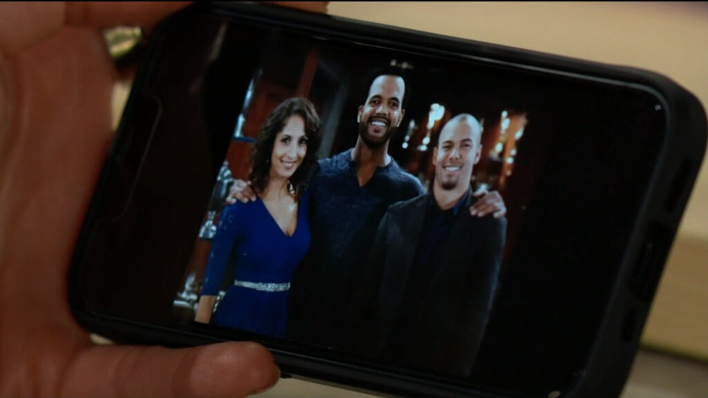 Lily's phone with a picture of her, Neil, and Devon. They all look happy.
