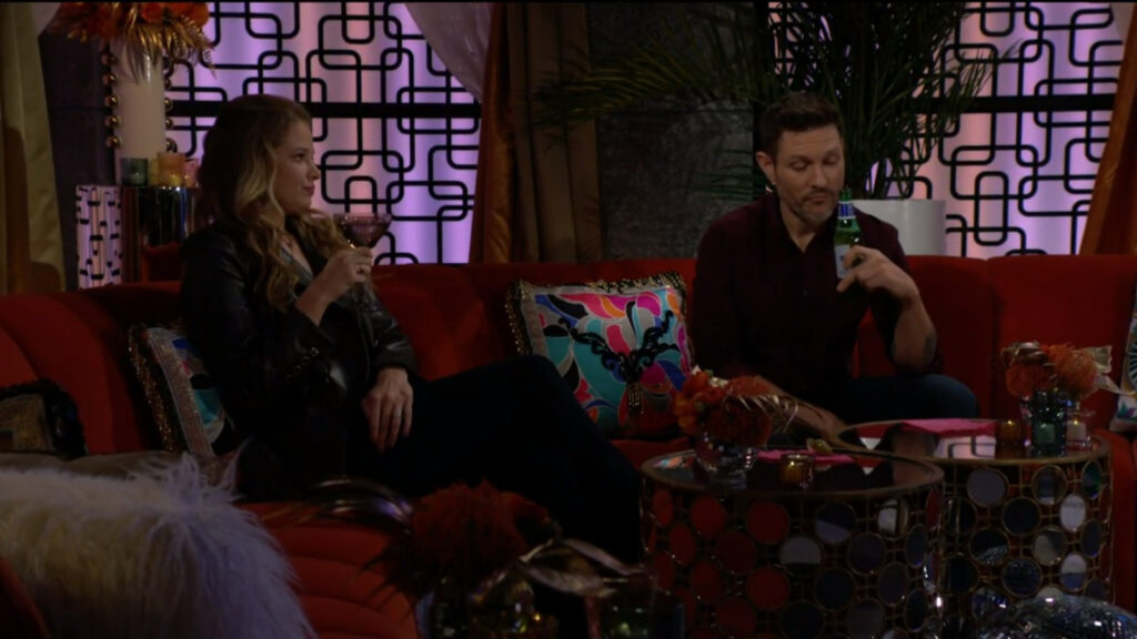 Summer and Daniel sit on a sofa in the Glam Club and talk