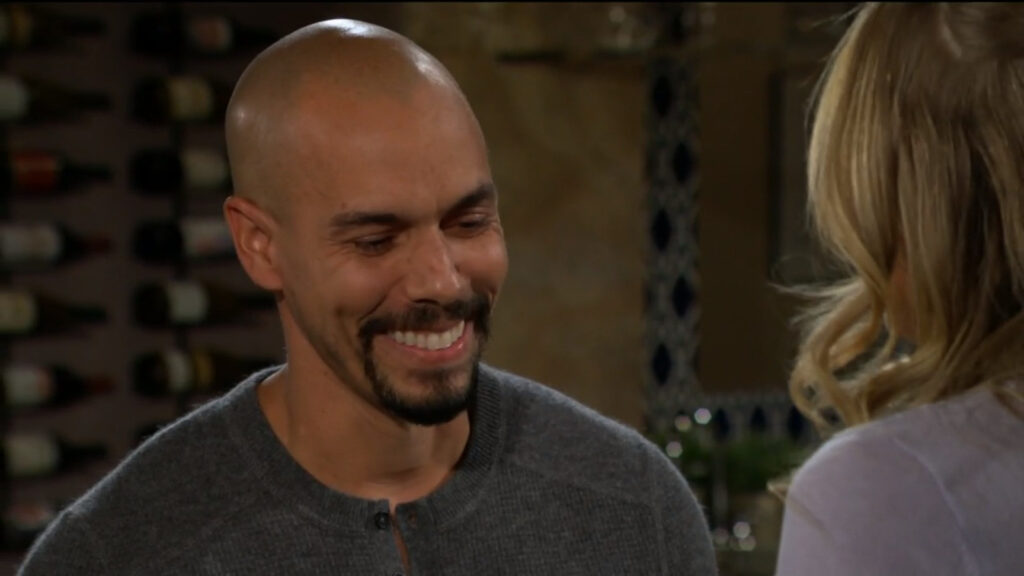 Devon smiles at Abby as they talk in his living room