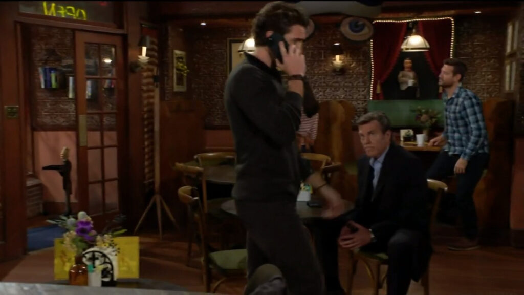 Chance is on the phone as he walks past Jack Abbott sitting at a table. Jack looks at him, worried.