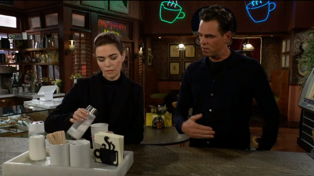 Victoria pours sugar into her coffee as she speaks with Billy
