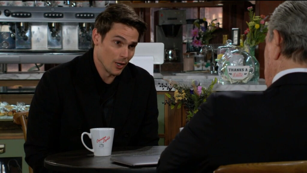 Adam sits and talks with Victor in the coffee shop