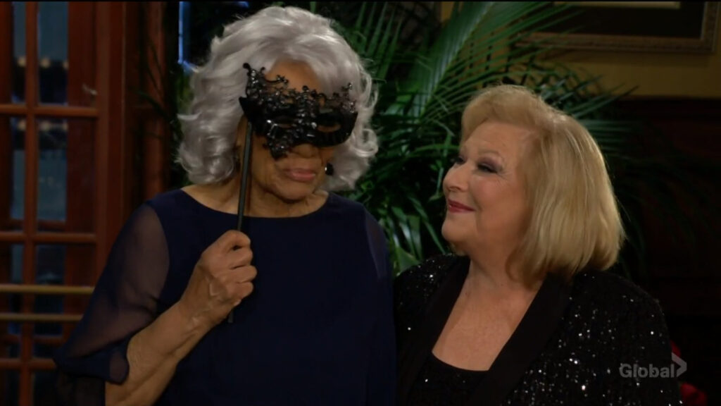 Mamie holds up her mask as she and Traci talk