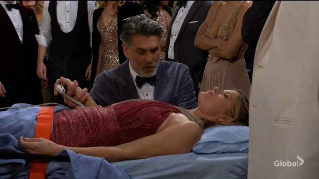 Jeremy holds an unconscious Phyllis's hand.