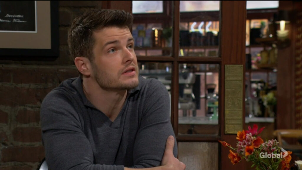 Kyle looks up at Sharon as they speak