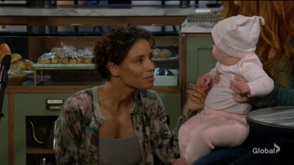 Elena kneels down and talks to the baby