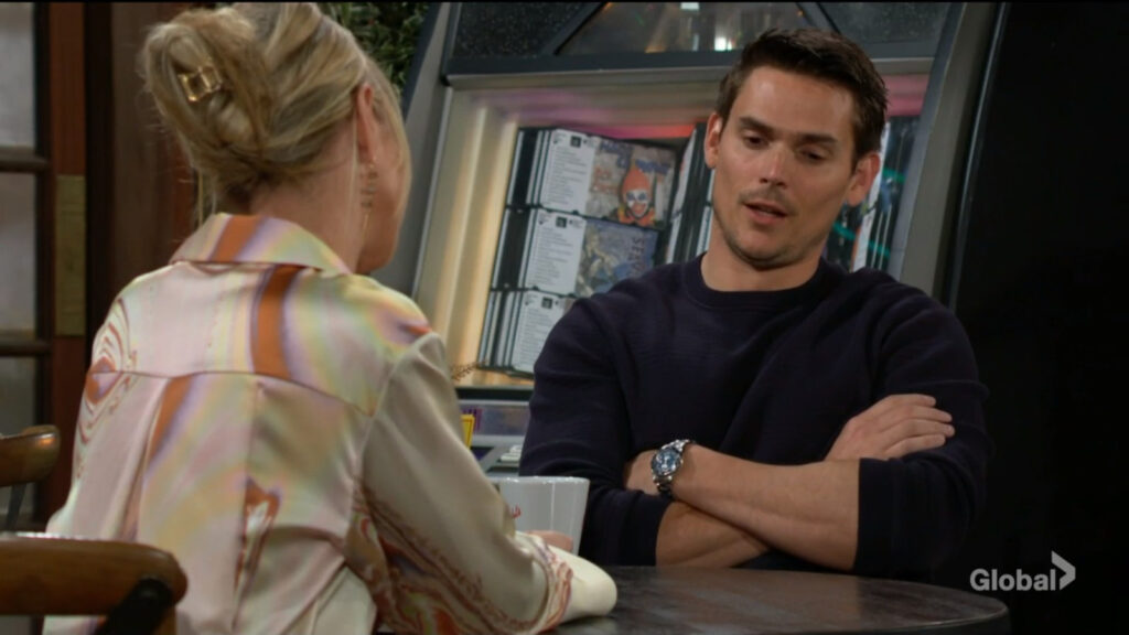 Adam crosses his arms as he talks with Sharon