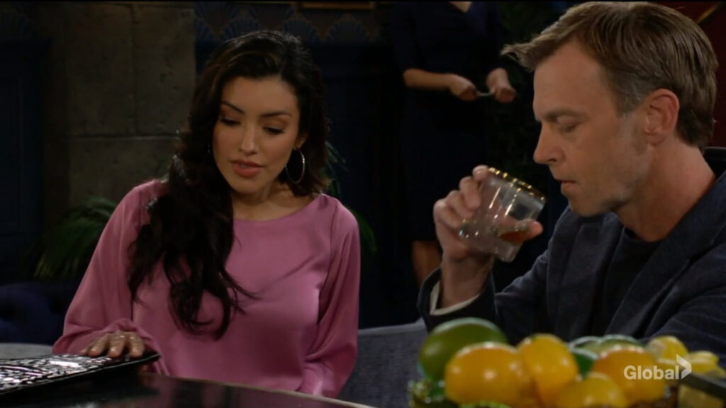 Audra talks to Tucker as he sips from his drink at the bar