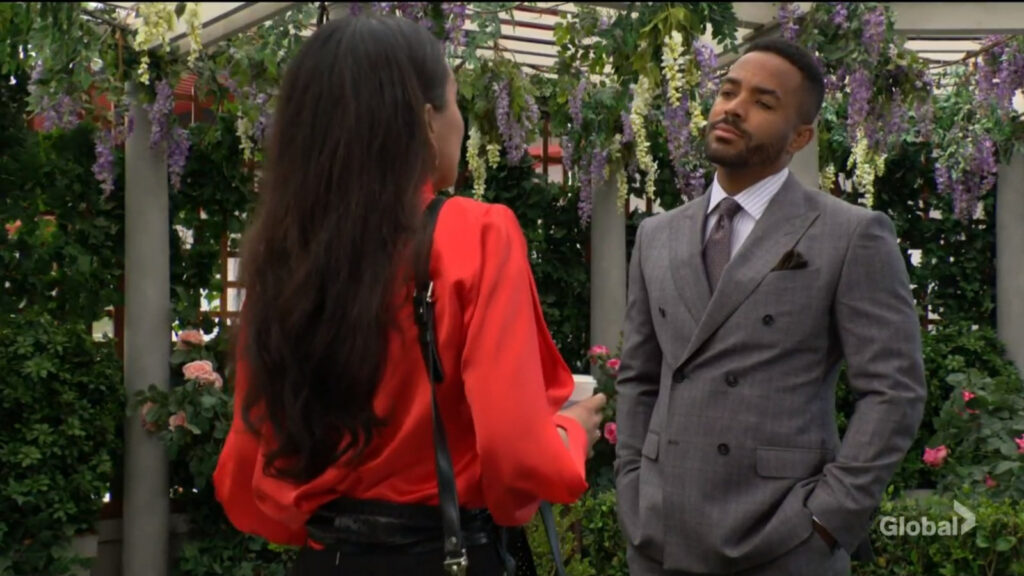 Nate has his hands in his suit pockets as he stands and talks with Audra.