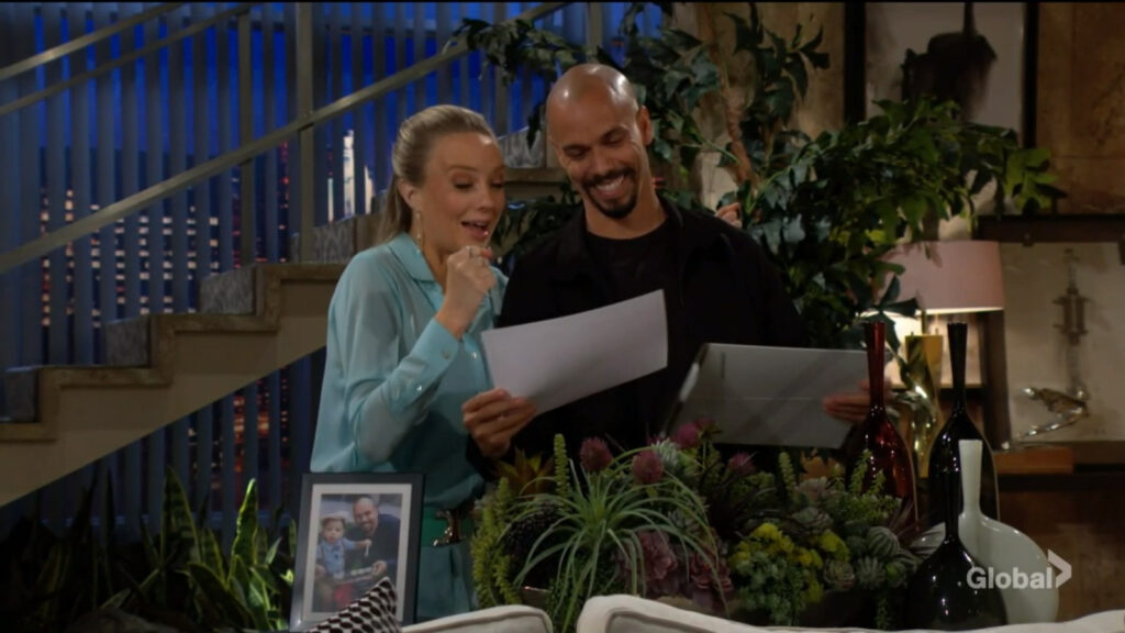 Abby smiles in excitement as Devon pulls the certificate out of the envelope.