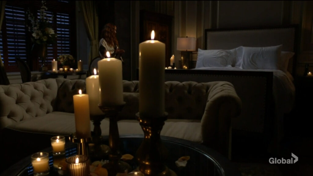 The hotel room is lit by candles as Mariah prepares the atmosphere.