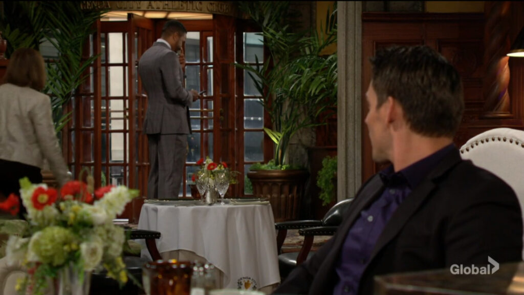 Adam looks over his shoulder and sees Nate in the lobby.