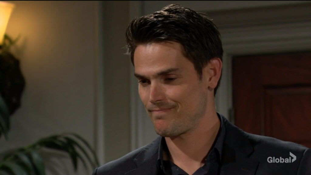 Adam smiles as he stands and talks with Sally.