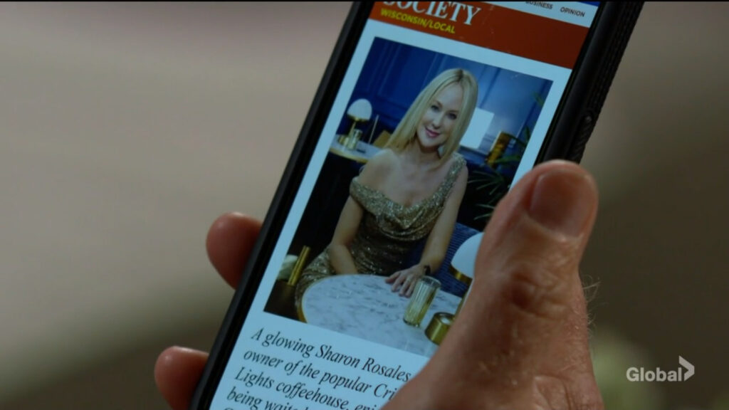 Cameron looks at a picture and article of Sharon on his phone.