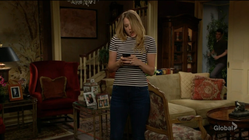 Summer looks at her phone and reacts when Kyle comes into the room.