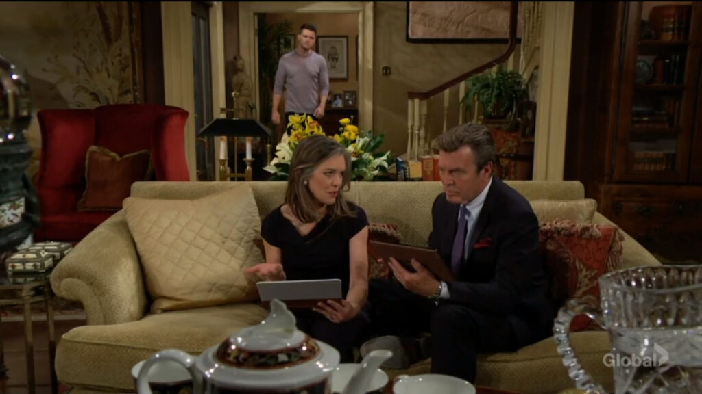Diane and Jack sit on the couch and talk as Kyle enters the room.
