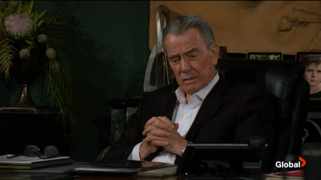 Victor sits with his hands folded as he talks with Victoria.