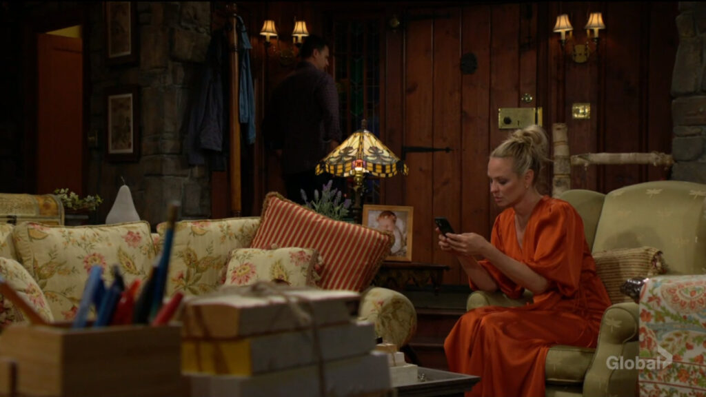 Sharon looks at her phone as she talks with Nick.