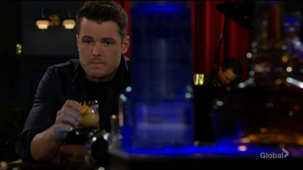 Kyle sits and drinks at the bar.