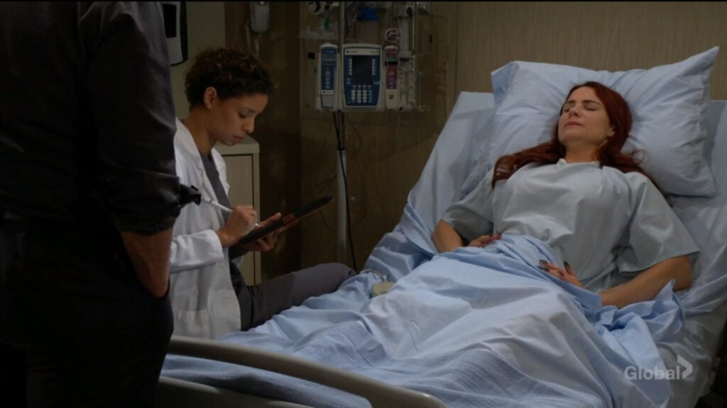 Elena talks with Sally as Adam looks on.