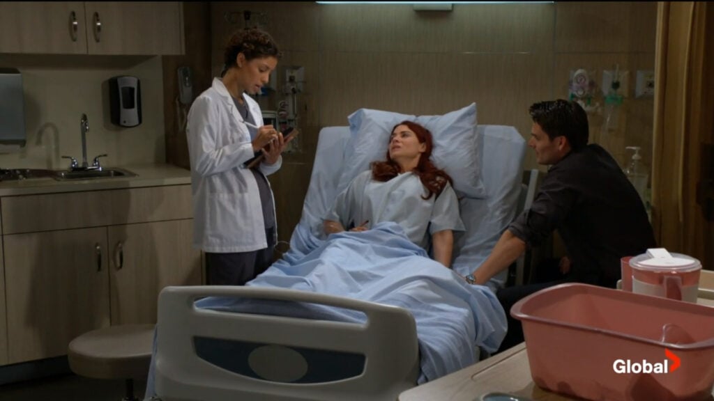 Elena writes in Sally's chart as she talks with Sally and Adam.