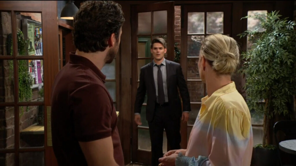 Adam walks into the cafe and Sharon and Chance look over at him.