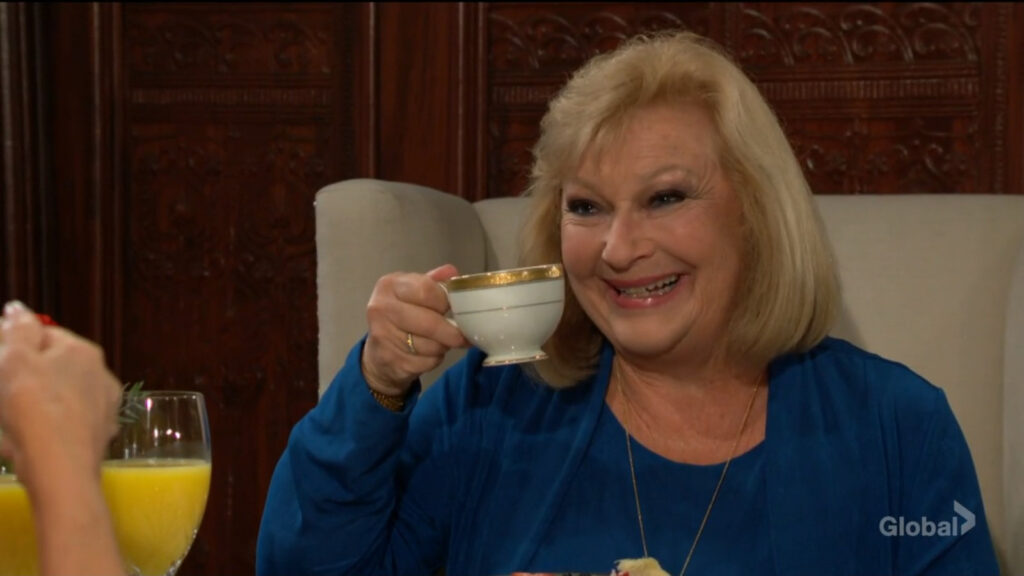A teary-eyed Traci raises her teacup in a toast with Zelda.