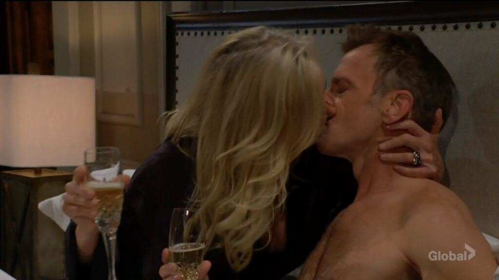 Ashley and Tucker kiss as they hold glasses of champagne.