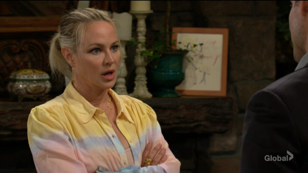 Sharon crosses her arms as she talks with Adam.