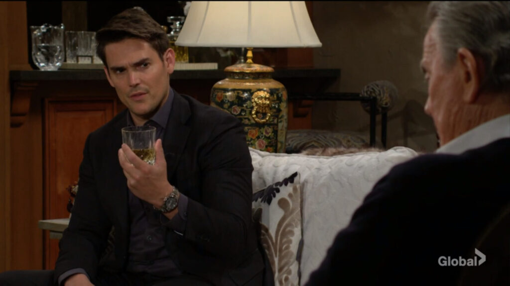 Adam holds a drink as he talks to Victor.