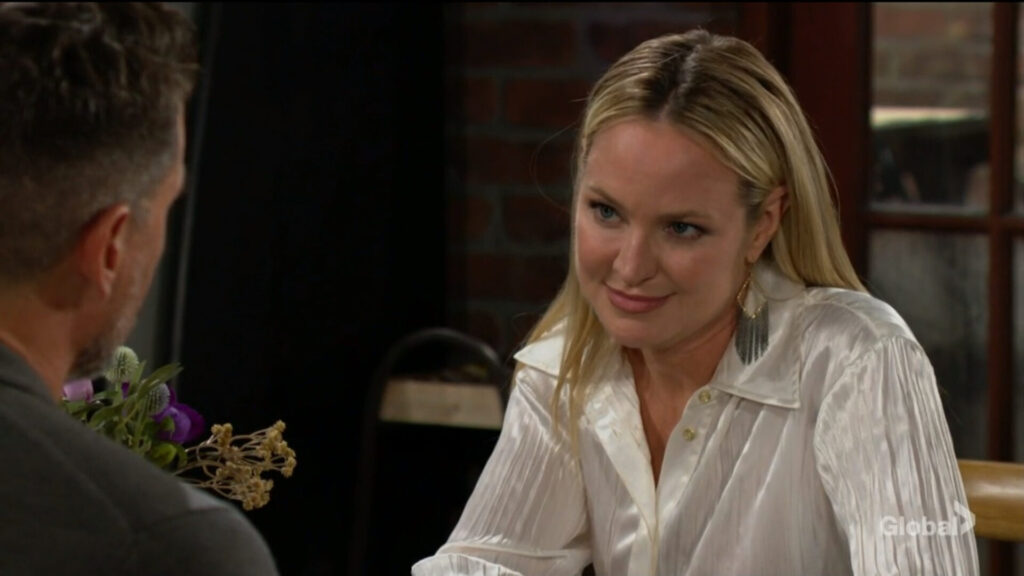 Sharon smiles at Nick as they talk.