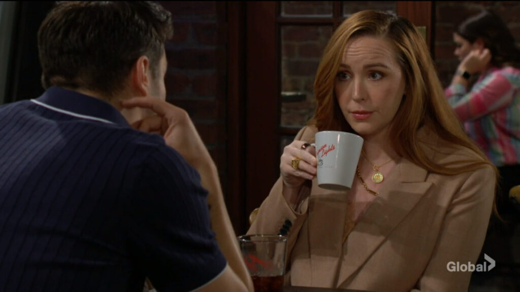 Mariah takes a sip of coffee as she talks with Kyle.