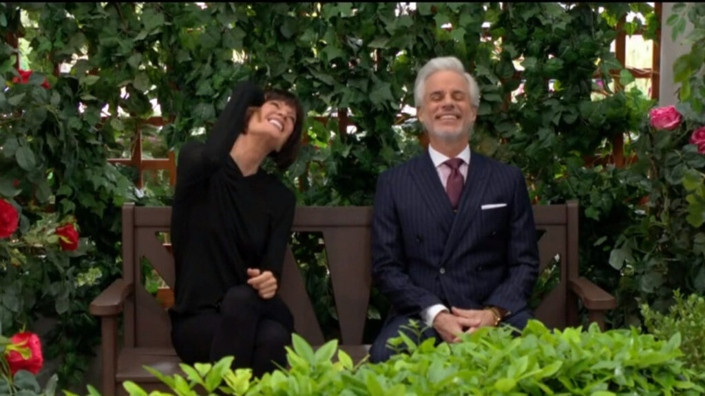 Phyllis and Michael laugh as they sit and talk on a park bench.