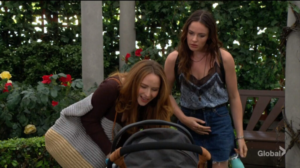 Mariah bends over the stroller while Tessa looks on.
