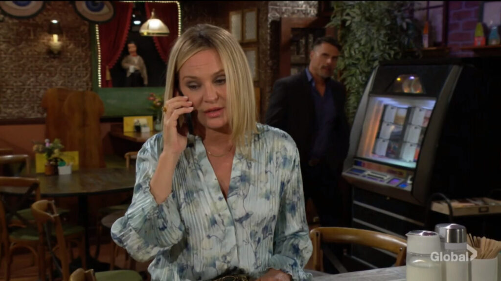 Sharon talks on the phone as Nick approaches.