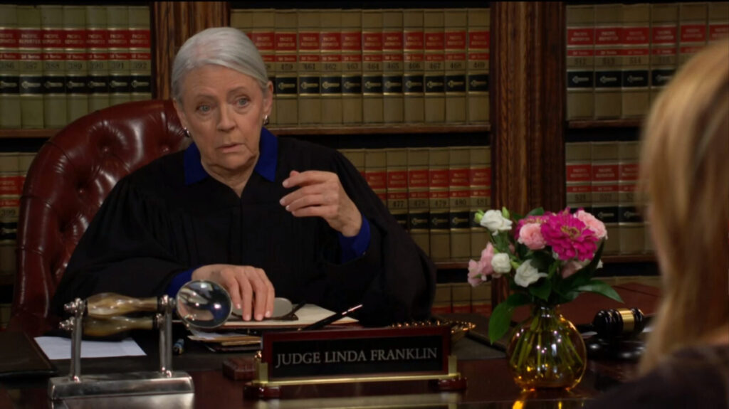 The judge gestures as she talks to Phyllis.
