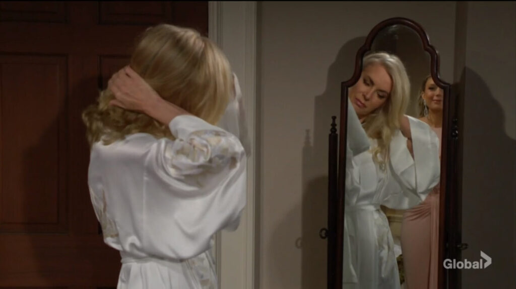 Ashley does her hair in the mirror as she talks to Abby.