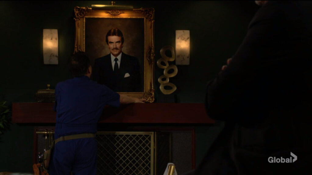 The workman puts Victor's portrait on the wall.