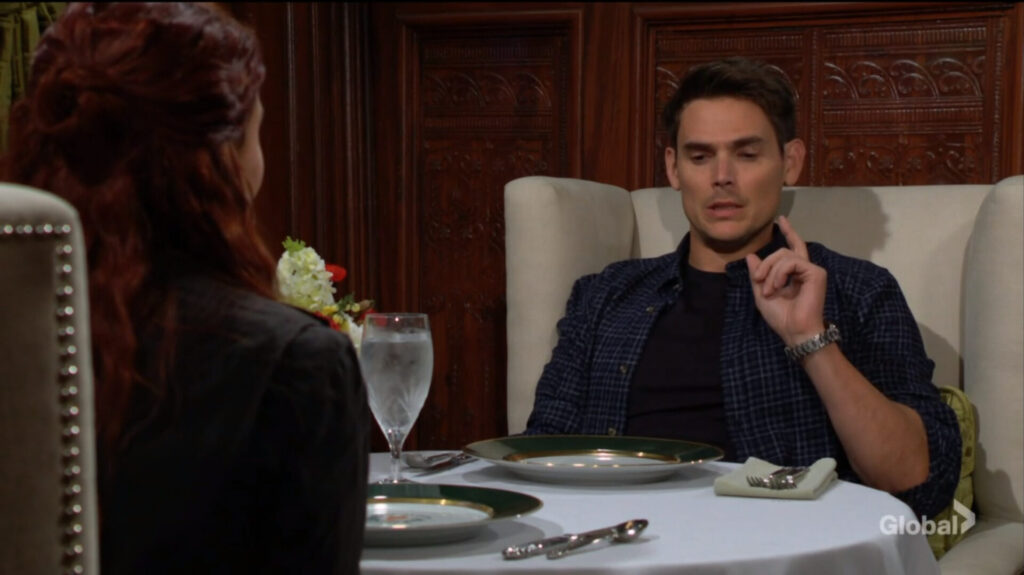 Adam gestures as he talks to Sally.