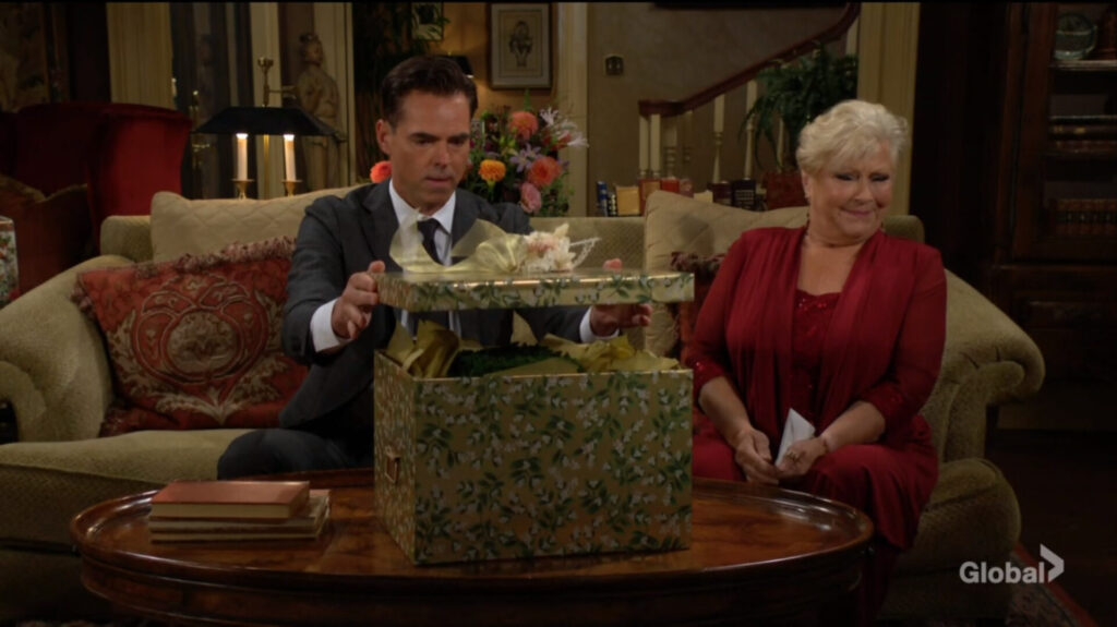 Billy opens the gift box as Traci watches.