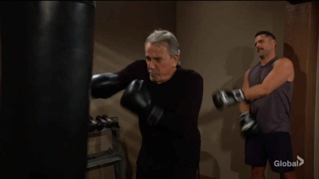 Victor punches the heavy bag as Nick looks on.