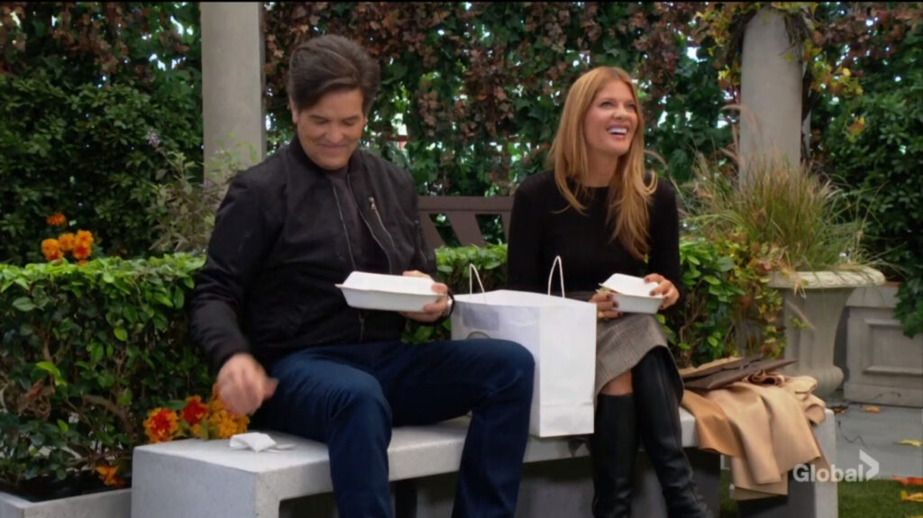 Danny and Phyllis sit on a park bench.