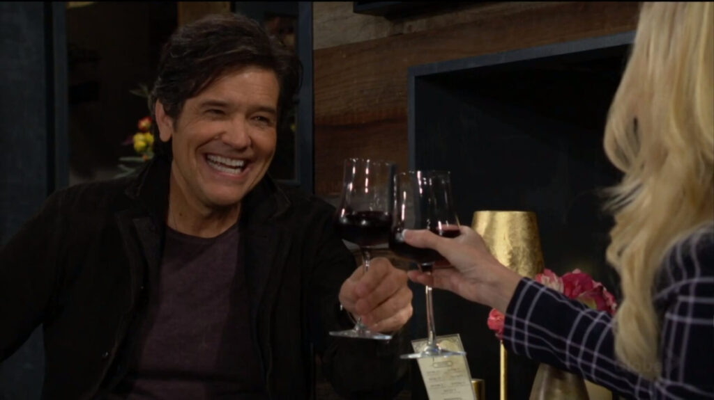 Danny smiles at he toasts with Christine.