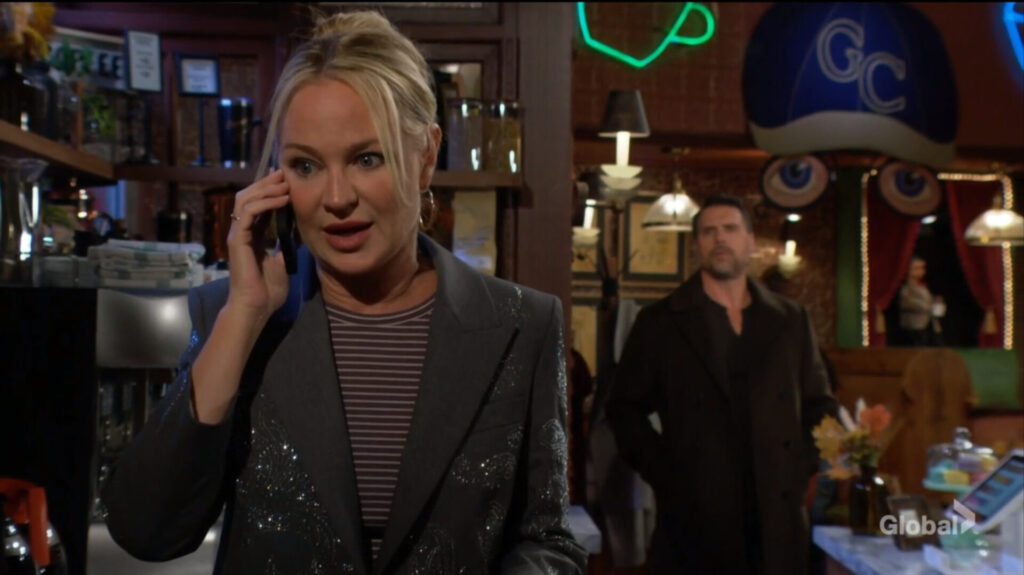 Sharon talks on the phone as Nick enters the cafe.
