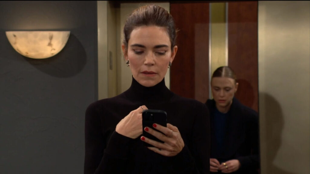Victoria looks at her phone as Claire steps out of the elevator.